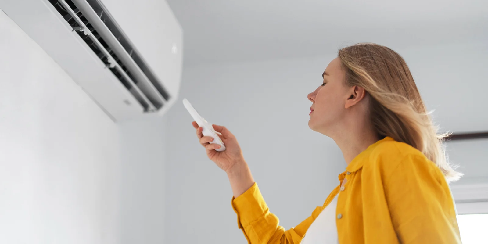A homeowner enjoying cool air from a wall-mounted air conditioner